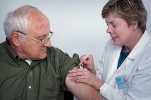 A doctor gives a senior man a vaccination